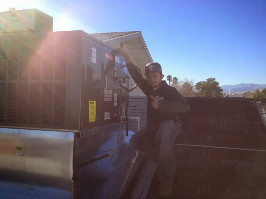 HVAC technician performing AC Tune-Up on a rooftop unit in Converse